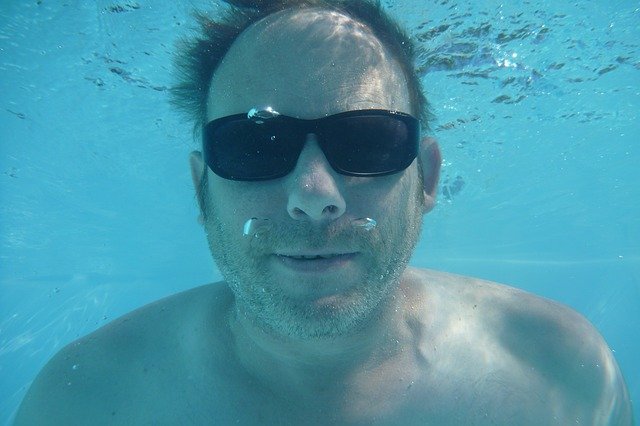 muž potápějící se v bazénu